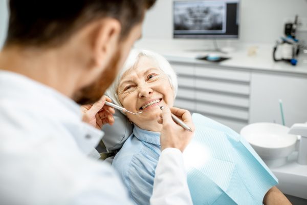 older woman in dental chair smiling
