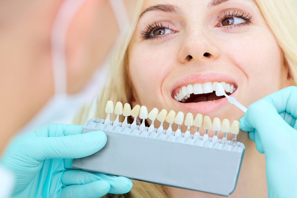 dentist applying teeth whitening treatment to woman patient